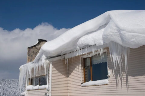 Ice buildup along roof edge in winter
