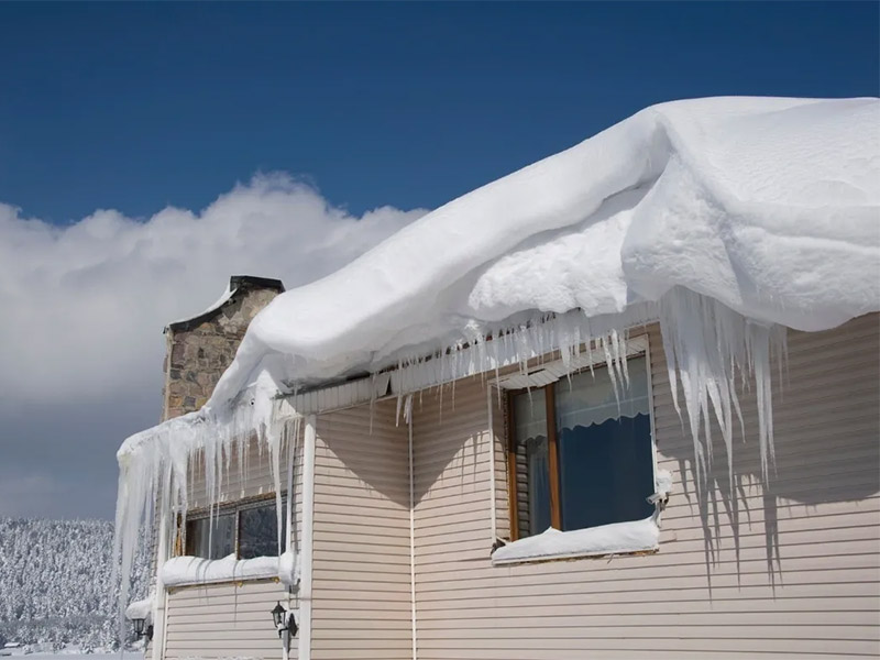 Ice buildup along roof edge in winter