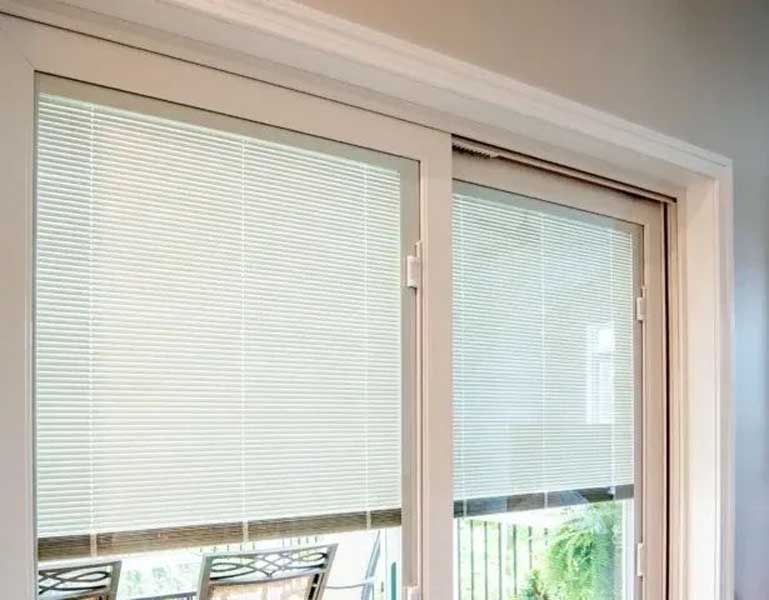 Sliding glass doors with built‑in blinds partially closed.